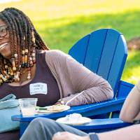 Brittany Jones '15 and man laughing as they sit on blue chairs